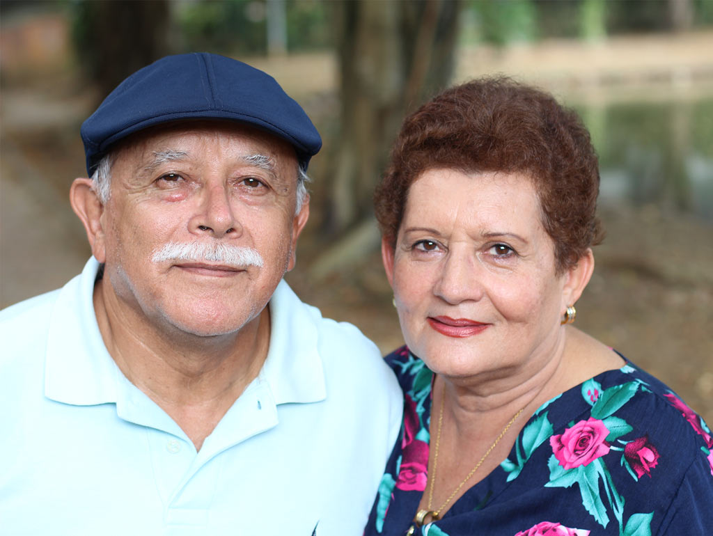 Photo of senior couple. Man wears a blue hat.